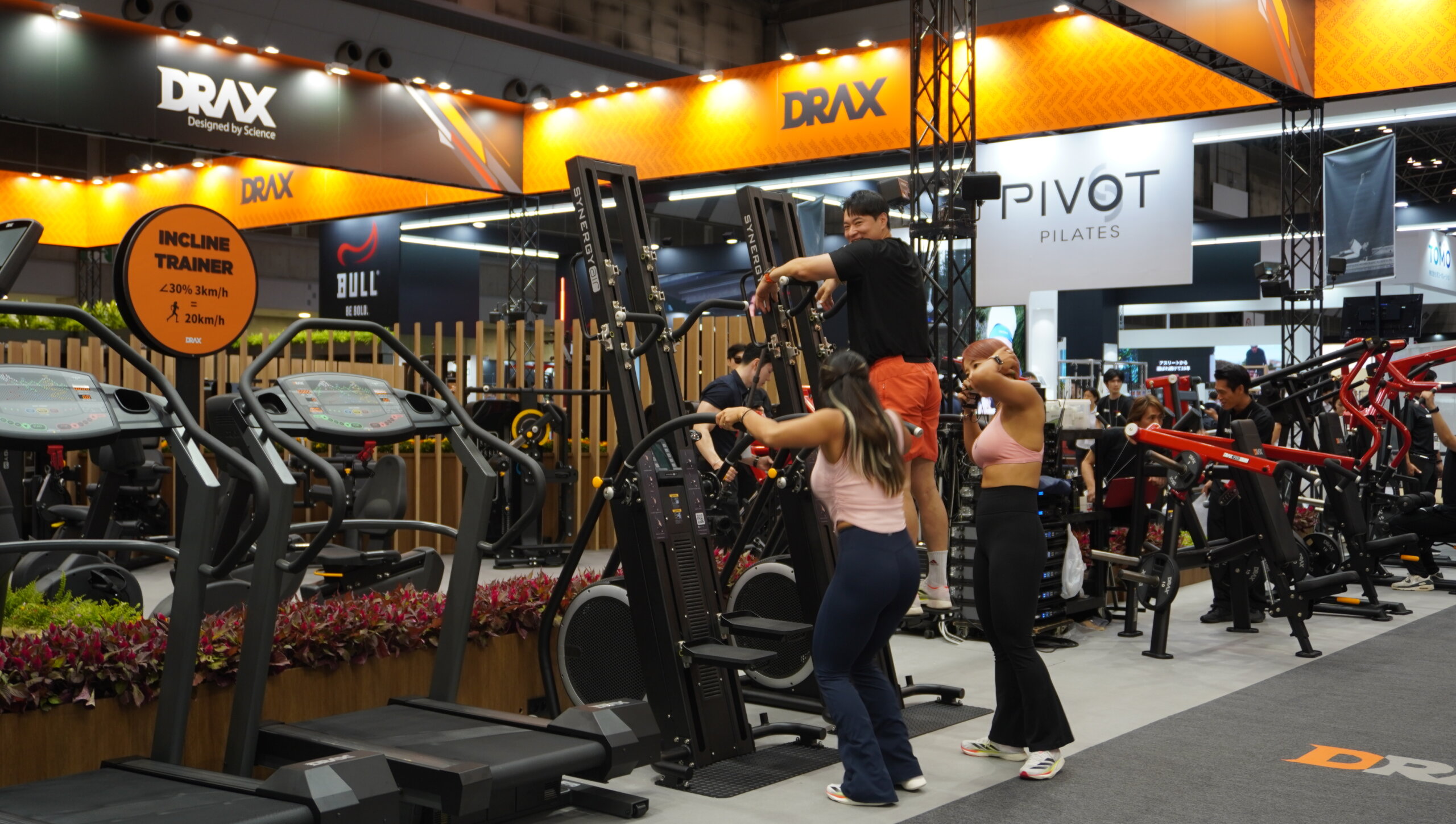 Busy SPORTEC expo hall with fitness equipment booths and visitors
