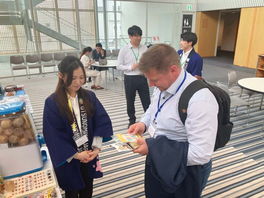海外の学会参加者に宇都宮をPR(左:駒場さん)